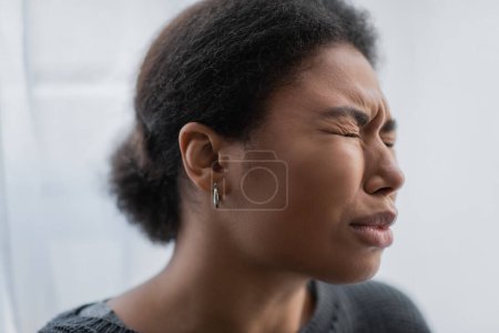 Foto de Triste mujer multirracial con crisis psicológicas llorando en casa - Imagen libre de derechos