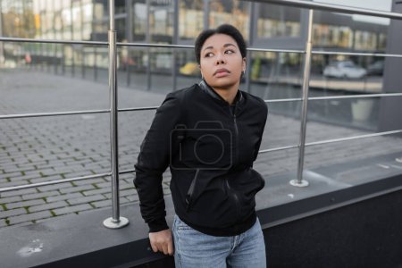 Young multiracial woman with psychological crisis standing on urban street 