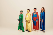 happy interracial children in colorful superhero costumes with cloaks and masks standing together on grey background in studio, World Child protection day concept  t-shirt #655801288