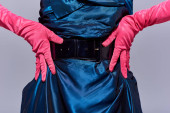 Cropped view of fashionable young woman in cocktail dress and pink gloves touching hips while posing isolated on grey, modern generation z fashion concept, details, close up  Mouse Pad 660423512