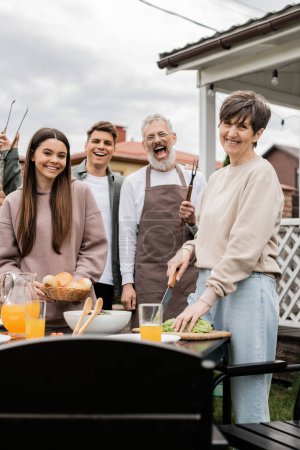 Photo for Family photo, excited and happy siblings near middle aged mom and dad, grill party, celebration of parents day concept, looking at camera on backyard of summer house, june - Royalty Free Image