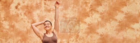 Photo for Body positivity, curvy and tattooed woman in crop top posing on mottled beige background, smiling with closed eyes, raised hand, representation of body, body shapes, generation z, youth, banner - Royalty Free Image