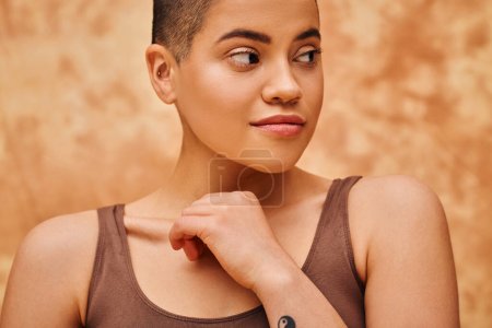 natural look, tattooed young woman with short hair posing on mottled beige background, individuality, modern generation z, beauty and confidence, body positivity movement, tattooed 
