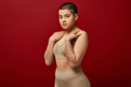 Photo for Body appearance, young tattooed woman in beige underwear posing on red background, body positivity, natural curves, comfortable in skin, curvy model, generation z, self love, looking at camera - Royalty Free Image