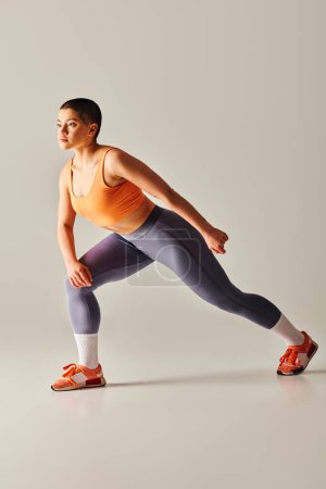 endurance, body positivity movement, athletic and curvy woman working out on grey background, short haired fitness model, training, sportswear, strength and health, empowerment and motivation 