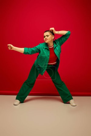 fashion choices, modern backdrop, emotional and young woman in stylish attire posing on red background, full length, generation z, youth culture, personal style, curvy fashion 