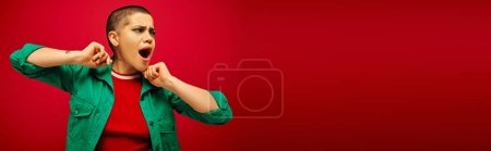 emotional, bold makeup, generation z, youth culture, shocked young woman with short hair posing with opened mouth on red background, youth culture, vibrant background, stylish appearance, banner 