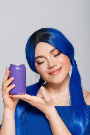 Sommerkonzept, erfreut junge Frau mit blauen Haaren, die Getränkedose auf grauem Hintergrund hält, Individualismus, Jugend und Lifestyle, lebendige Farbe, Selbstausdruck, einzigartige Identität, moderne Subkultur 