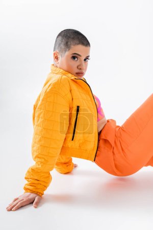 urban fashion, young woman in colorful clothes posing on grey background, looking at camera, urban style, individualism, vibrant and youthful energy, urban fashion, generation z