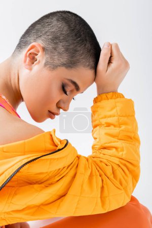 personal style, young woman in colorful clothes posing with closed eyes on grey background, urban style, individual style, vibrant and youthful energy, urban fashion, generation z, casual attire 