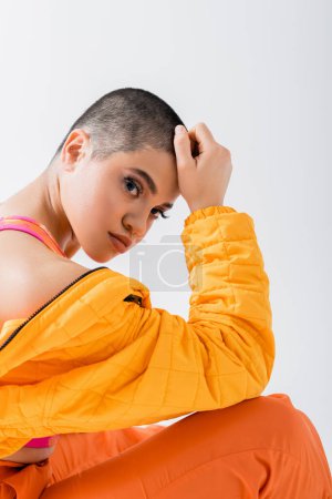 self expression, young woman in colorful clothes posing on grey background, looking at camera, urban style, individual style, vibrant and youthful energy, urban fashion, generation z, casual attire 