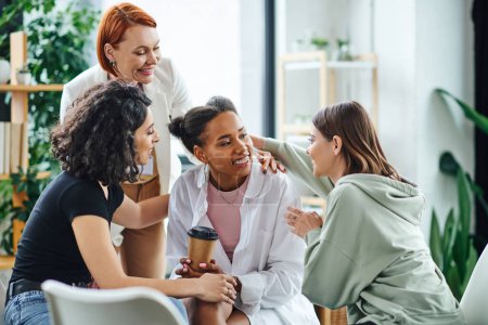 multicultural women embracing happy african american girlfriend near pleased redhead psychologist during group therapy in consulting room, friendship and mental wellness concept