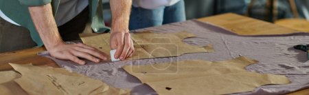 Photo for Cropped view of craftsman marking cloth near sewing patterns and blurred colleague while working in print studio, collaborative business owners working together, banner - Royalty Free Image