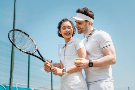 letni romans i sport, sztandar, wesoły mężczyzna uczy dziewczynę jak grać w tenisa na korcie