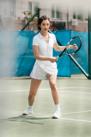 szczęśliwy kobieta gracz w sportowej sukience gospodarstwa rakietki na kort tenisowy, sport letni, hobby i zdrowie