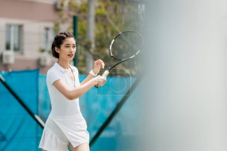 Spielerin im sportlichen Kleid mit Schläger auf Tennisplatz, Freizeit und Sport, gesunder Lebensstil