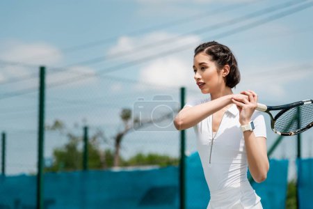 beautiful woman in active wear holding racket and playing tennis on court, sport and summer