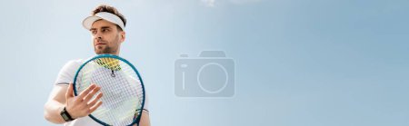 Photo for Banner, handsome man in active wear and visor cap holding tennis racquet on court, sport and leisure - Royalty Free Image