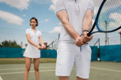 sporty man holding tennis racquet near girlfriend on court, couple sport, motivation, hobby Sweatshirt #665313982