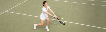 banner, forehand, overhead view of female player in active wear playing tennis, racket and ball