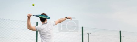 banner, backhand, man playing tennis on court, holding racket, hitting ball, backhand, back view