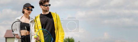 banner, summer sport, couple in sunglasses standing on tennis court with rackets, athletes fashion