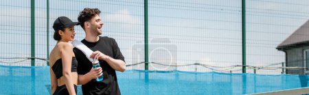 Photo for Banner, happy couple in active wear standing with towel and sport bottle on tennis court, sport - Royalty Free Image