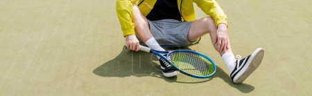 Banner, abgeschnittene Ansicht eines männlichen Tennisspielers, der auf dem Platz sitzt und Schläger in der Hand hält, Mann in aktiver Kleidung