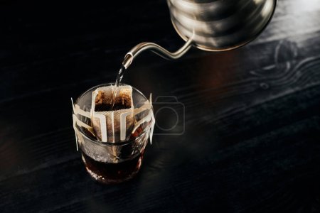  przelewanie espresso, nalewanie wrzącej wody z czajnika kroplowego do szklanki z kawą w worku filtracyjnym