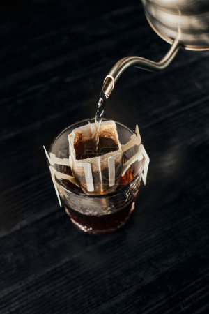 alternatives Gebräu, aromatischer Espresso, kochendes Wasser in Glas gießen mit Kaffee in Papierfilter