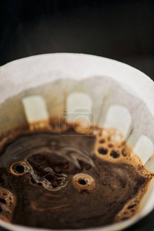 close up view of freshly brewed aromatic coffee with foam in paper filter bag, V-60 style espresso
