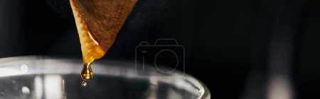 vue rapprochée de l'expresso frais coulant du sac filtrant dans une cafetière en verre, style V-60, bannière