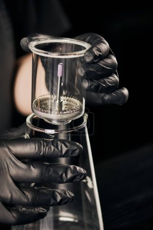 Photo for Barista in black latex glass assembling siphon coffee maker and glass pot in coffee shop - Royalty Free Image