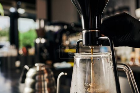 Foto de Vista parcial de barista que regula la cafetera sifón mientras prepara espresso en la cafetería - Imagen libre de derechos
