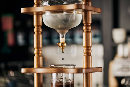 alternative brewing of espresso, cold drip coffee maker, cold water dripping on fresh ground coffee 