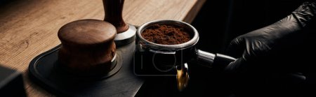 Photo for Banner, barista holding portafilter with grinded coffee, tamper, wooden table, cafe culture - Royalty Free Image