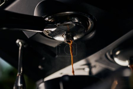 Kaffeeextraktion, schwarzer Kaffee, heißer Espresso, der in die Tasse tropft, professionelle Kaffeemaschine 