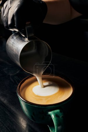 Latte Art, Barista bereitet Cappuccino zu, Kanne mit Milch, Tasse mit Espresso, Arabica, Gourmet 