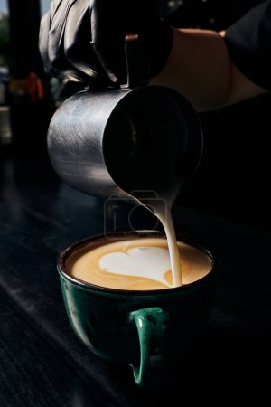 Latte Art, Barista bereitet Cappuccino zu, Kanne mit Milch, Tasse mit Espresso, Arabica, Kaffee 