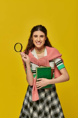 happy young woman holding books and magnifier, zoom, discovery, student in college outfit, smile