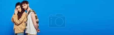 Photo for Stylish couple in casual wear posing on blue backdrop, woman and man looking at camera, banner - Royalty Free Image