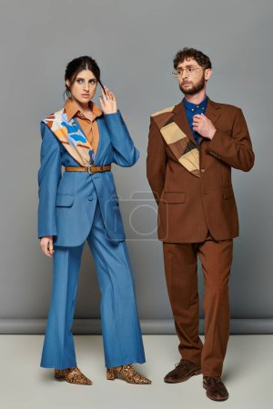 bärtige Männer und Frauen in maßgeschneiderten Anzügen posieren vor grauem Hintergrund, braun, blau, Modeshooting, Paar
