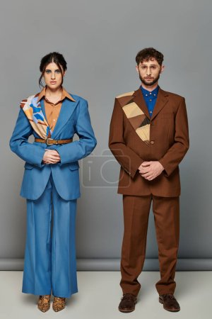 bearded man and woman, tailored suits, posing on grey backdrop, brown, blue, fashion shoot, couple