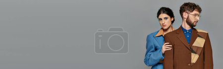 fashion shoot, trendy couple in suits, tailored, stylish formal attire, grey background, banner