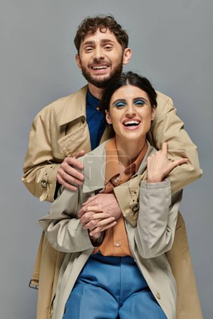 cheerful couple, outerwear, fall season, grey background, man and woman in trench coats, autumn