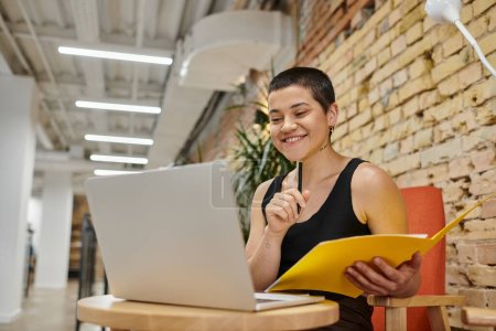 tattoo: no sugar, joyful woman using laptop, holding folder, working on startup project, coworking