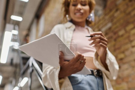 focus on papers, african american woman holding documents, blurred, coworking, startup, close up