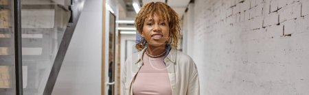 Téléchargez les photos : Heureuse femme afro-américaine avec bretelles regardant caméra, projet de démarrage, génération z, bannière - en image libre de droit