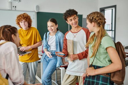happy teenagers talking in classroom, back to school, classmates communicating during school break