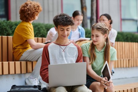 Photo for Back to school, happy boy and girl using gadgets near school, teenage students outdoors, e-study - Royalty Free Image
